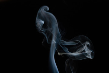 Abstract smoke background with copy space on black background. Blue-white smoke rising from the incense stick