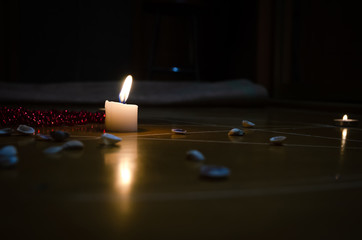 pentagram is painted on the floor, candles are lit, beads are lying, shells are scattered. concept...