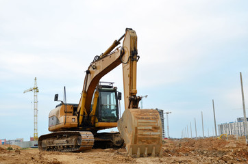 Excavator digs the ground for the foundation and construction of a new building. Road repair, asphalt replacement, renovating a section of a highway, laying or replacement of underground sewer pipes