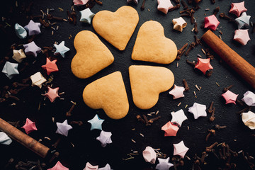 Composition with decorated heart shaped cookies on dark,black background.