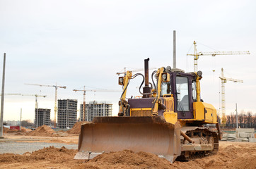 Bulldozer during of large construction jobs at building site. Land clearing, grading, pool excavation, utility trenching and foundation digging. Crawler tractor,  dozer, earth-moving equipment.