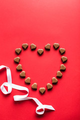 Heart shaped chocolates on red background for Valentine's day