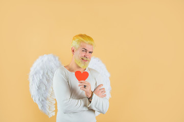 Cupid holds valnetine's heart. Handsome angel Cupid. Love concept. Valentine angel. Bearded man...