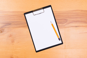 pen on blank white document sheet on wood clipboard on white wood table top view space