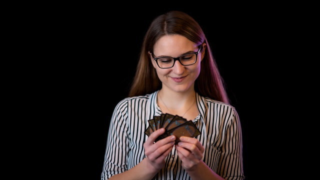 grinsende junge Frau mit Magic the Gathering Karten