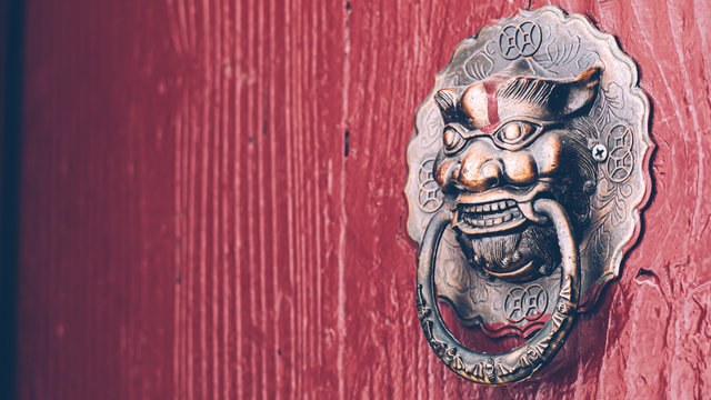 Chinese Style Old  Red Door With Copper  Lion Head Doorknob . Traditional Architecture Decoration To Protect Evil .