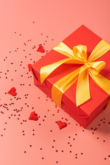 Obraz premium red box tied with a gold ribbon. the ribbon is tied on a box in the form of a beautiful bow. holiday gift concept