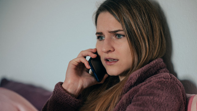 junge Frau telefoniert und ist &uuml;berrascht