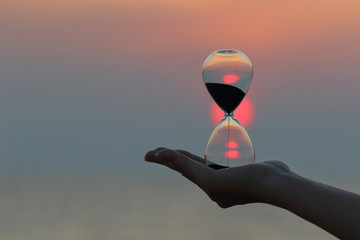 Hourglass in hand at sunset.