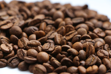 Close up view of brown roasted coffee beans. Blend of 70% arabica and 30% robusta is used for this photo. Theme of drinks ingredients. Coffee background. Selective focus.