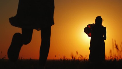 A child runs to his mom. Against the backdrop of a beautiful landscape at sunset