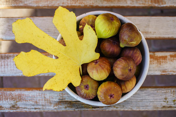 Ripe figs freshly harvested from a tree in a bowl in autumn with leaf