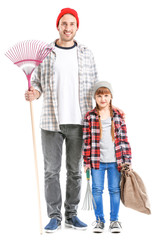 Man and his little daughter after autumn leaves clean-up on white background