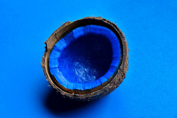 Blue painted coconut on color background