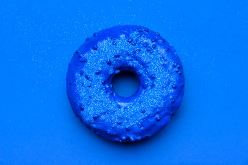 Tasty blue donut on color background