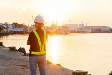 Silhouettes of asian woman engineer holding wrenches and radio communication (walkie talkie) she...