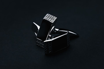 Stylish men's stainless steel cufflinks with black stone on a dark background. Men's fashion...