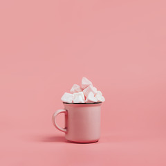 pink mug on a pink background filled with marshmallows in the form of hearts. next to it is a box with a gift for Valentine's Day. valentine's day holiday concept