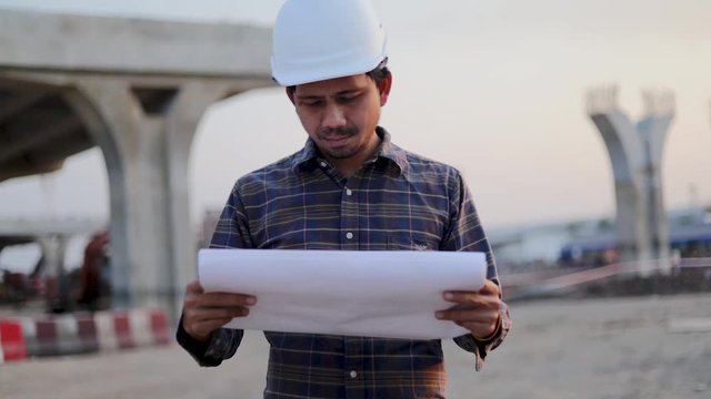Slow motion Asian engineers worker and looking into the blueprints at construction site