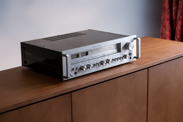 Fototapeta premium Vintage Stereo Receiver Standing on the Wooden Sideboard, Side View