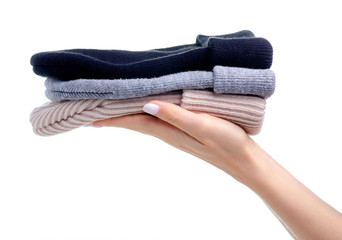 Colorful knit winter hats in hand on white background isolation