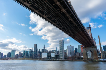 Fototapeta premium Below the Queensboro Bridge along the East River with the Midtown Manhattan Skyline in New York City