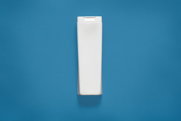 Minimal style. Classic Blue color of the Year 2020. White plastic bottle isolated over phantom blue...