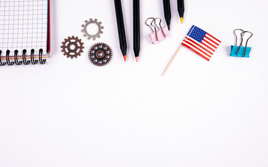 Flag of the United States of America. Stationery, note book and gears on a white table