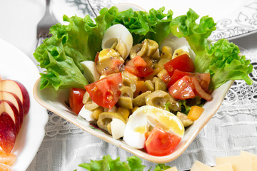 Greek salad with olives, tomatoes, feta cheese, onions in blue bowl on wooden background. Close up. Selective focus.