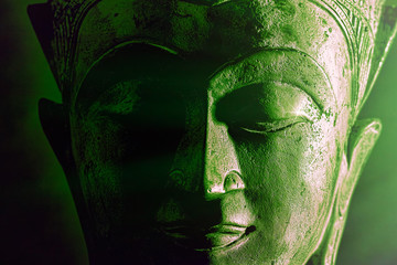 Spiriitual enlightenment. Green buddha face statue close-up. Bold graphic image