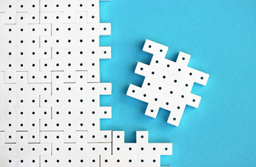 White puzzle pieces on the  turquoise background show cohesion, teamwork and agreement.