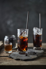 Ice coffee in a tall glass on wooden table..