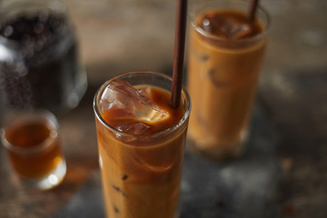 Ice coffee in a tall glass on wooden table..