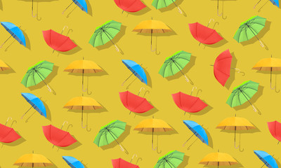 Multi-colored umbrellas pattern on yellow background.