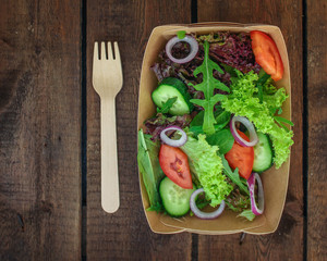 Healthy salad, leaves mix salad in paper disposable tableware (mix micro greens, cucumber, tomato,...