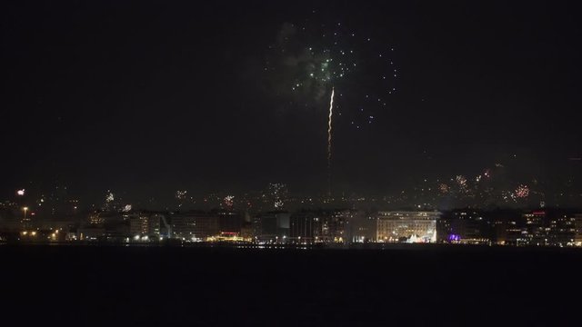 Series of fireworks above large residential area landscape at night. New Years Eve January 01 2020 pyrotechnics at Thessaloniki, Greece for the coming of New Year, seen from the city waterfront.