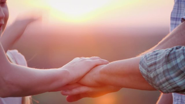 A team of volunteers puts their hands on top of each other before starting work. Motivation and teamwork concept