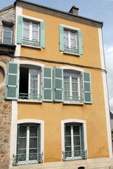Fototapeta na wymiar Ville de Mortagne-au-Perche, vieil immeuble du centre ville, volets gris-vert et fenêtres blanches, département de l'Orne, France