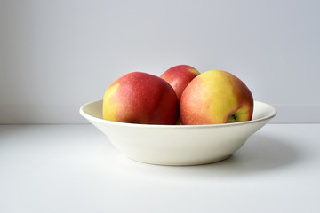 Apples in the plate on white table