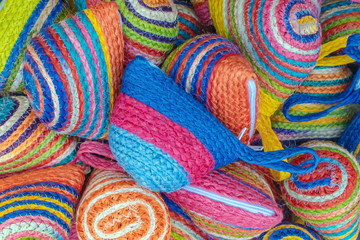 Close up to vintage handicraft colorful bags by yarn for sale at local market in Thailand. Selective focus.