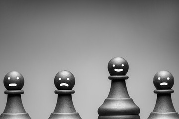 Greyscale image of chess pieces with faces
