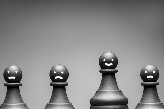 Greyscale image of chess pieces with faces