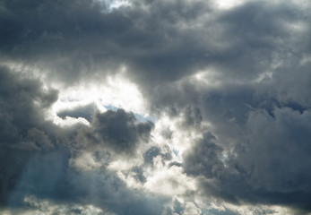 The sun in the clouds on a blue sky.