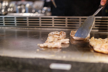 Japanese chef cooking meat in teppanyaki restaurant