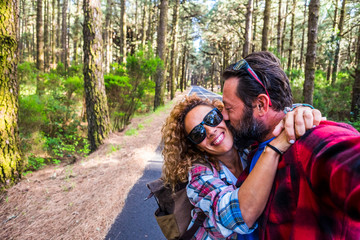 Happy people caucasian couple enjoying the outdoor leisure activity together traveling in a forest...