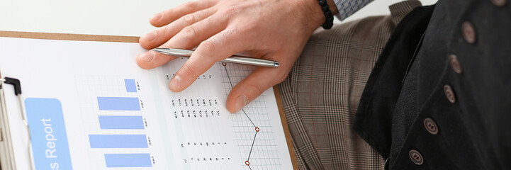 Male hands hold clipboard pad financial statistics