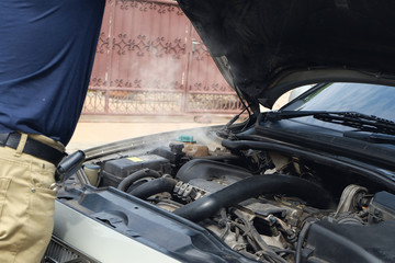 Driver on the road having problem with a car. Engine overheating and radiator is dry.