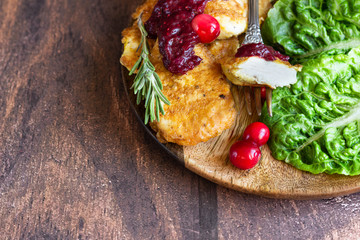 Traditional Viennese chicken schnitzel served with cranberry sauce and green salad. Wooden...