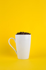 cup of coffee with coffee beans on yellow background
