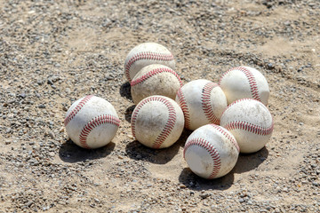 8 baseball balls grouped on the ground
